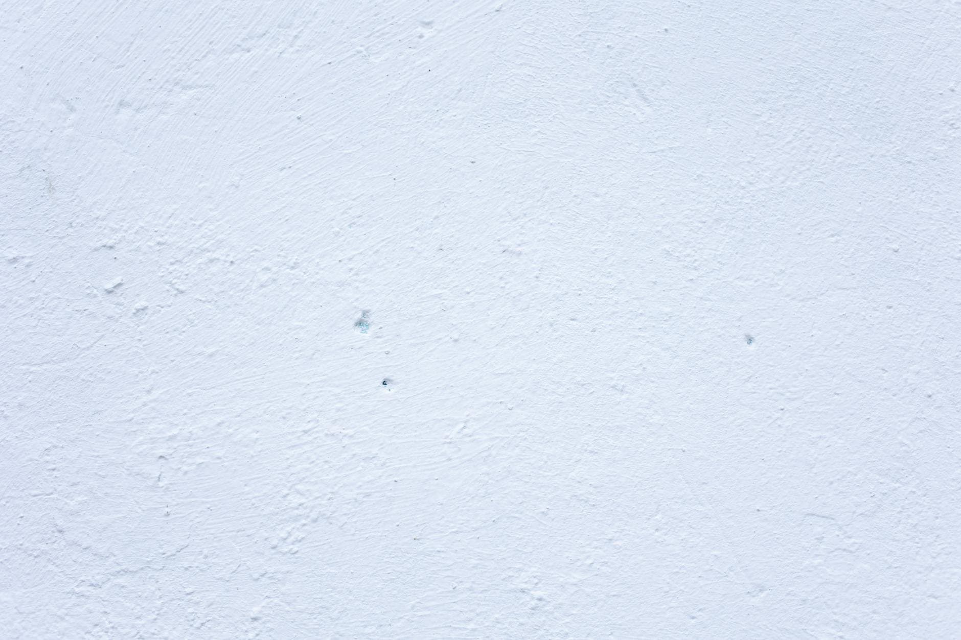 A textured white wall perfect for use as a minimal and clean background.