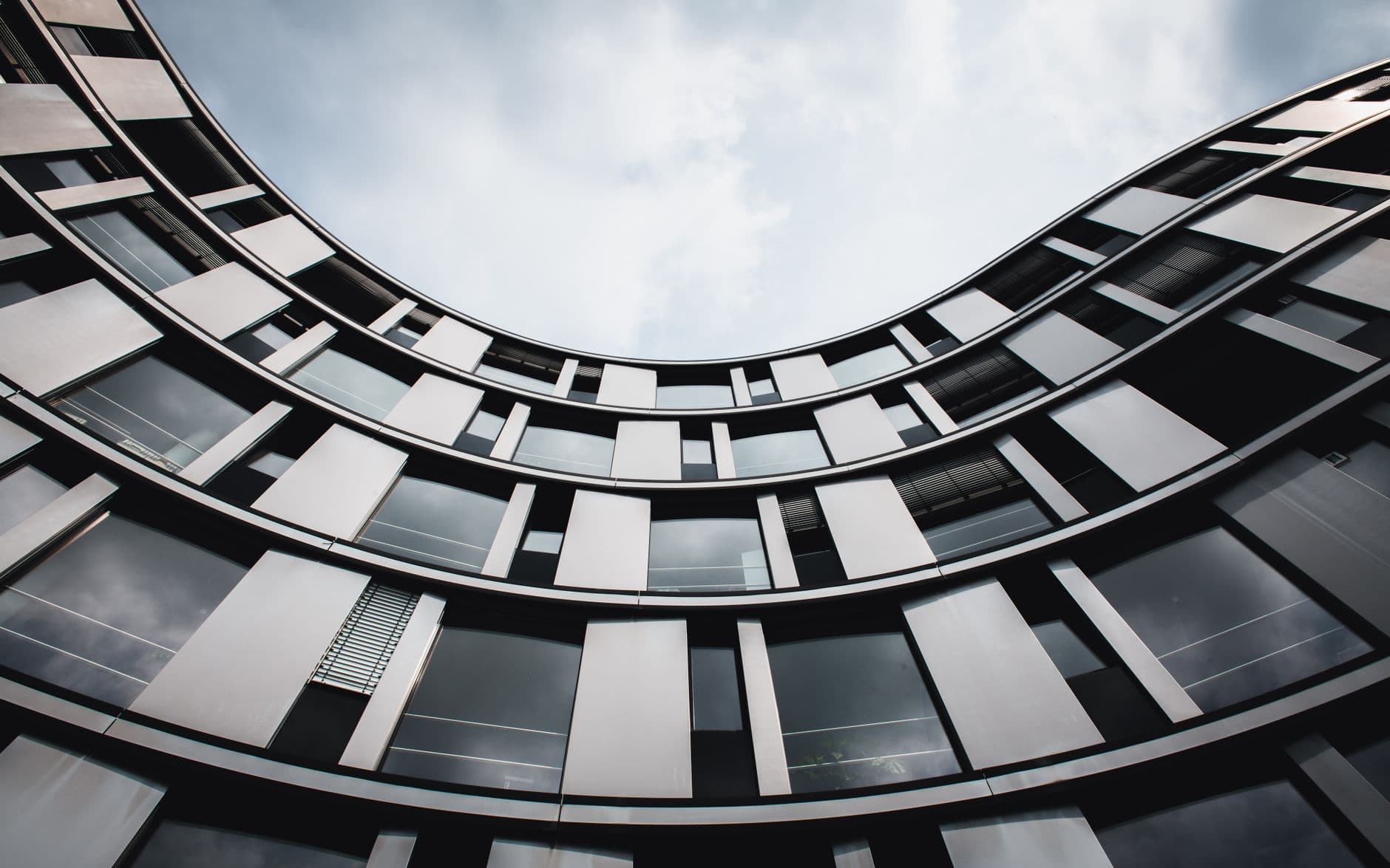 Stunning upward view of a modern curved building in Hamburg. A blend of glass and steel.