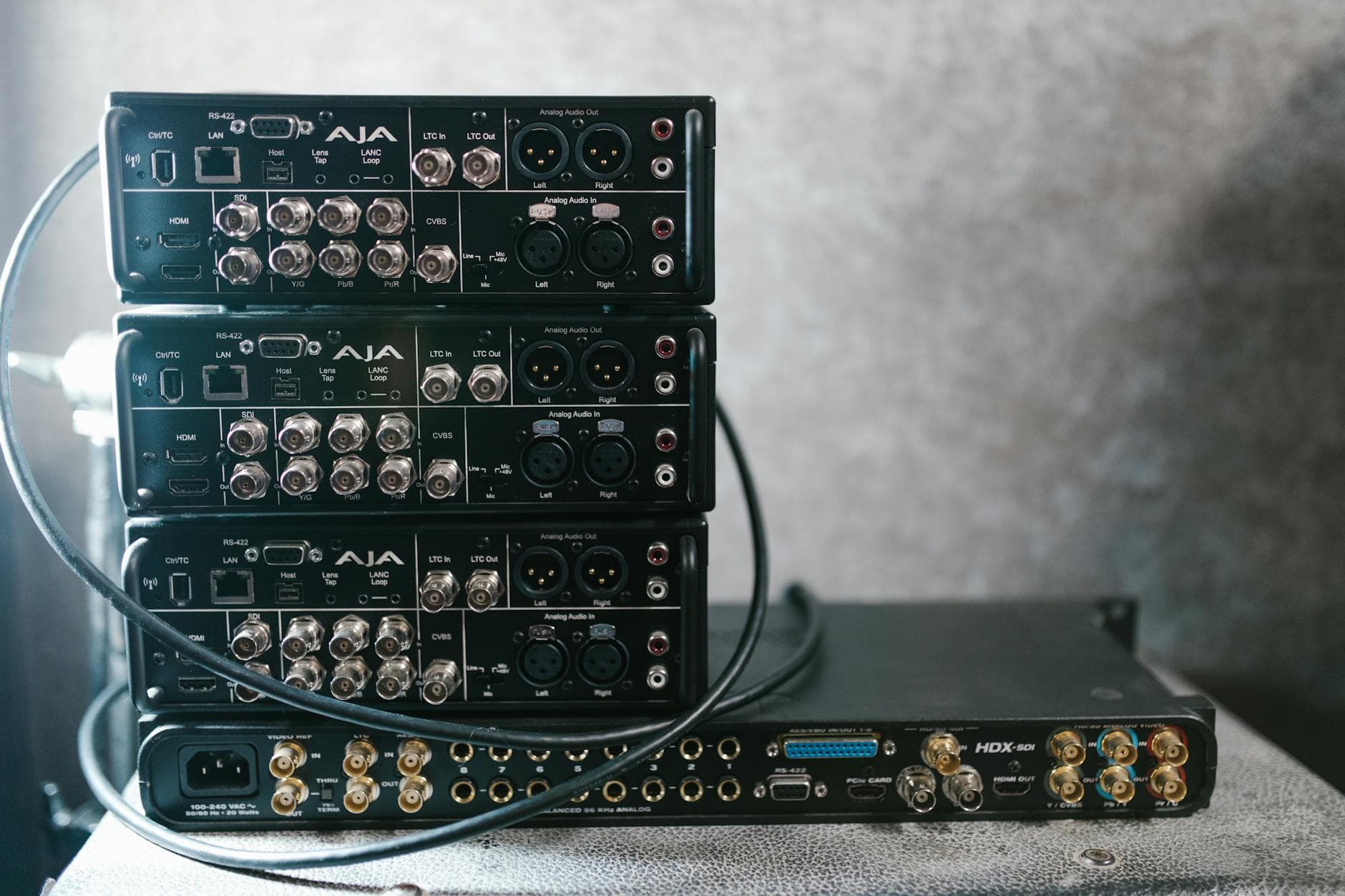 Stacked professional audio video equipment with multiple connectors for recording studio settings.