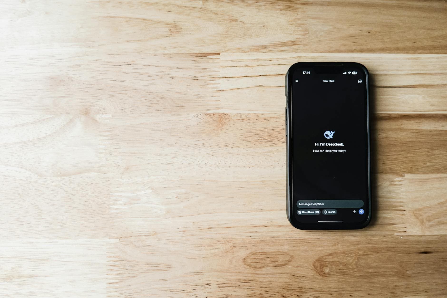 Scrabble tiles spelling out Google and Gemini on a wooden table, focusing on AI concepts.
