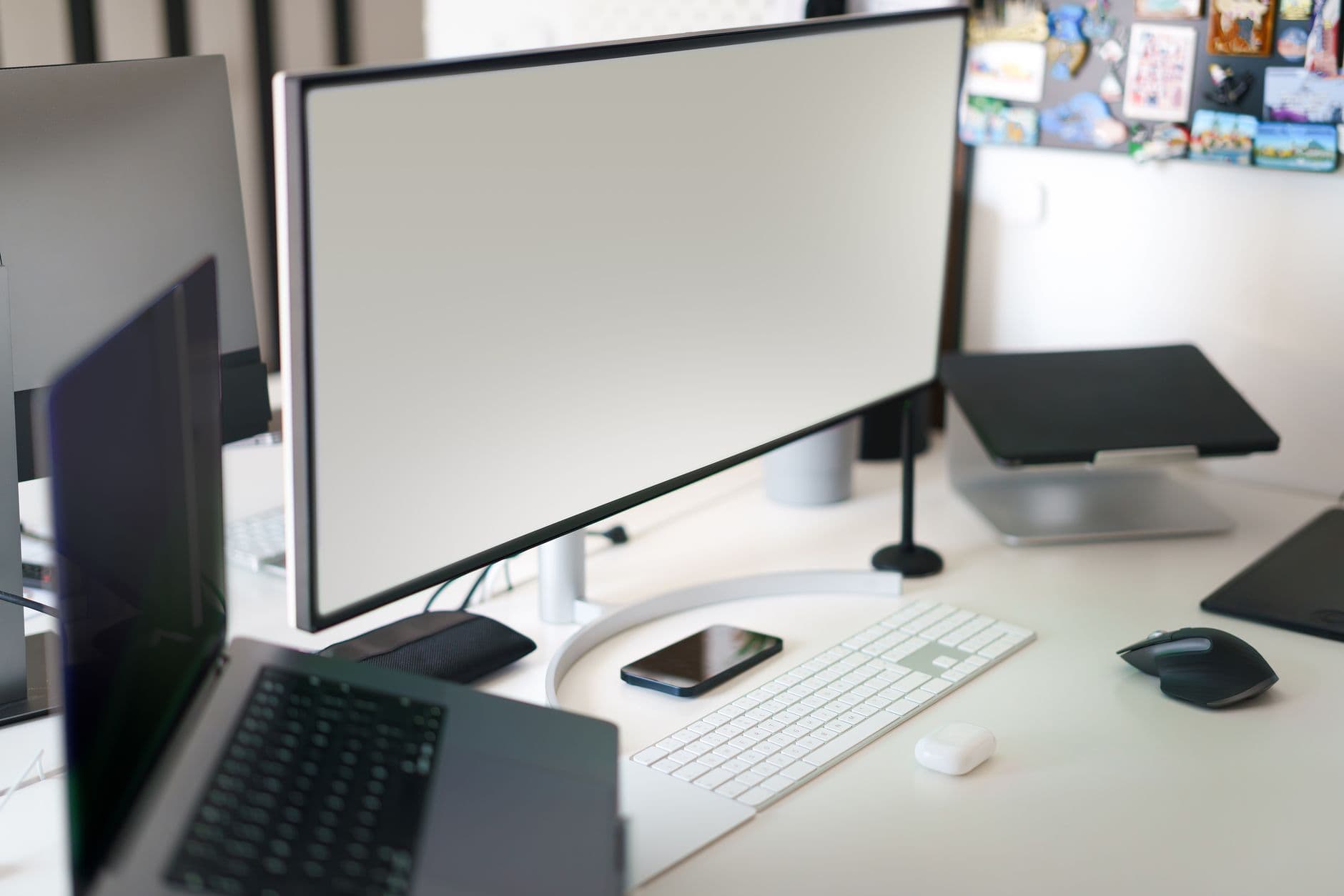 Clean and modern office workspace featuring a desktop setup with a large monitor and accessories.
