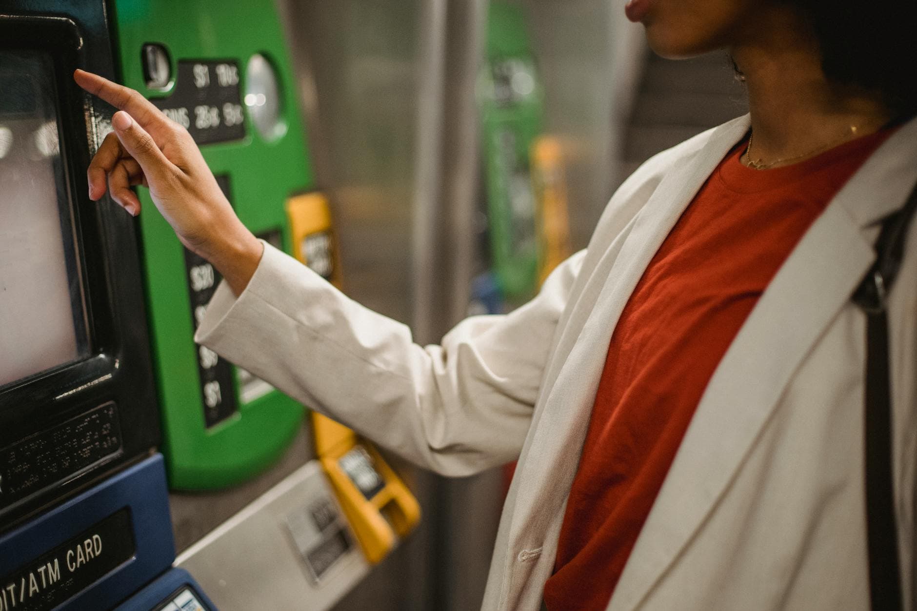 A woman interacts with a ticket machine in a transportation station, highlighting modern convenience.