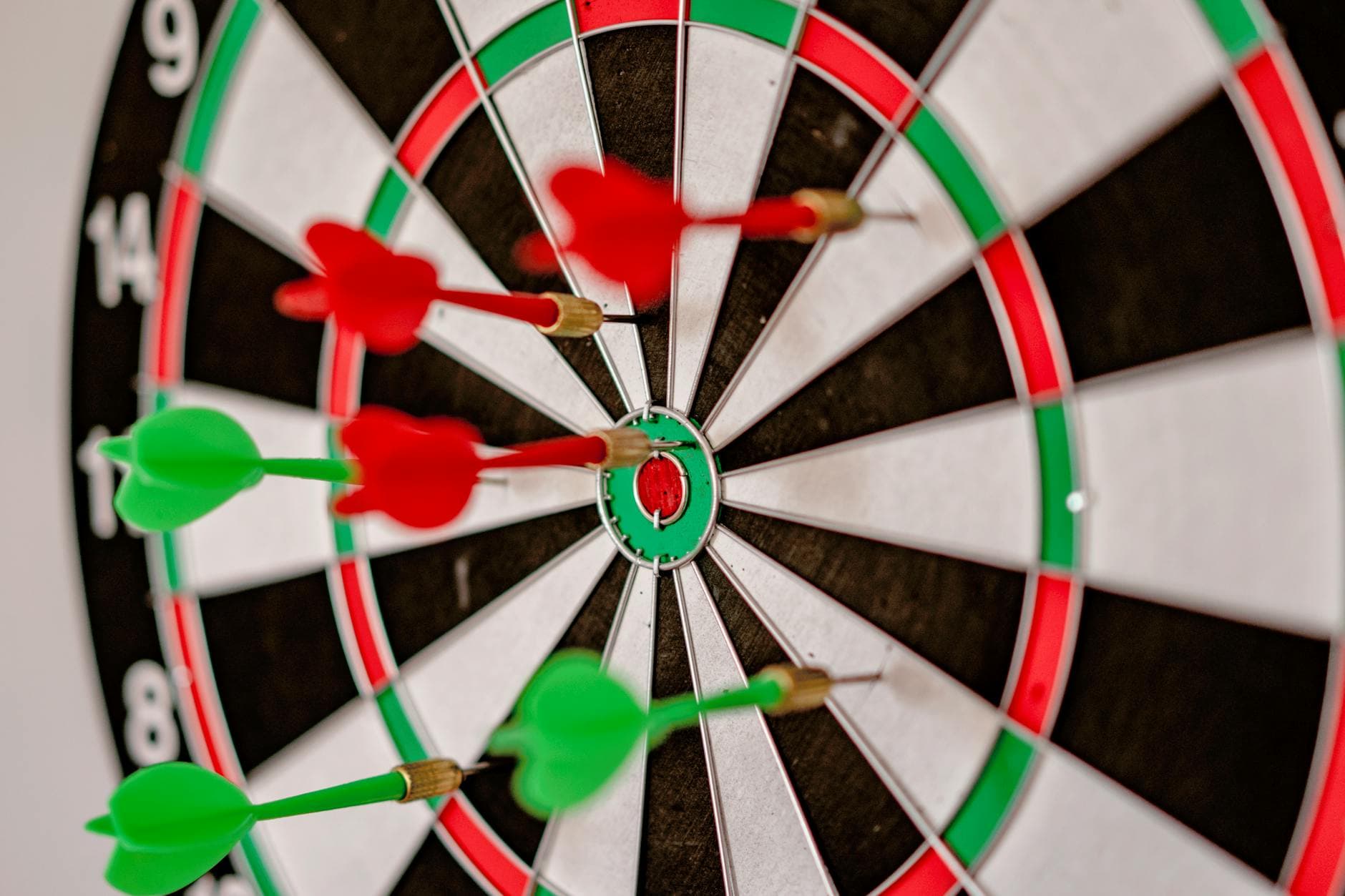 Close-up focus on darts hitting the bullseye on a dartboard, symbolizing precision and accuracy.