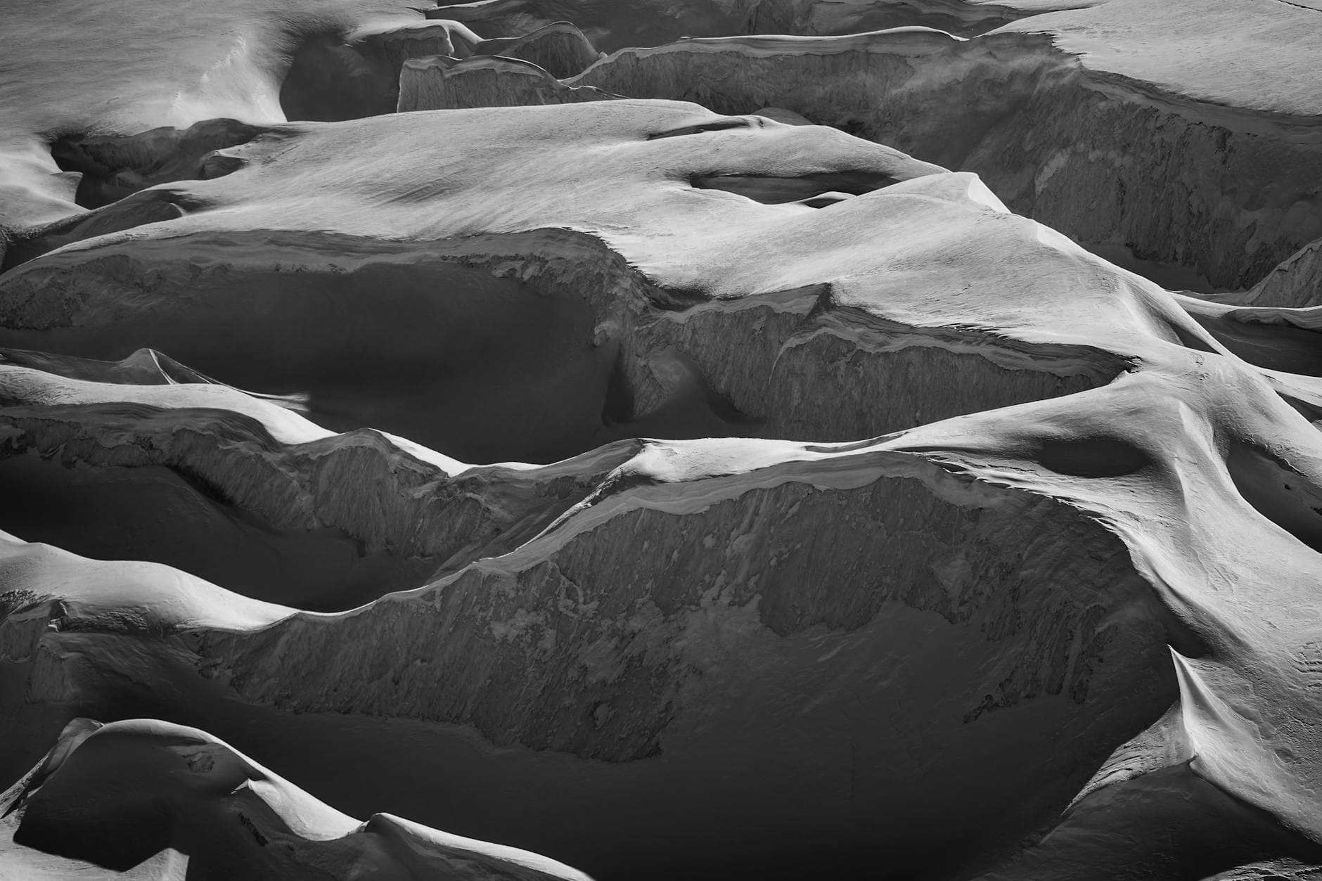 Captivating black and white photo of Saas Fee's snowy mountain formations.