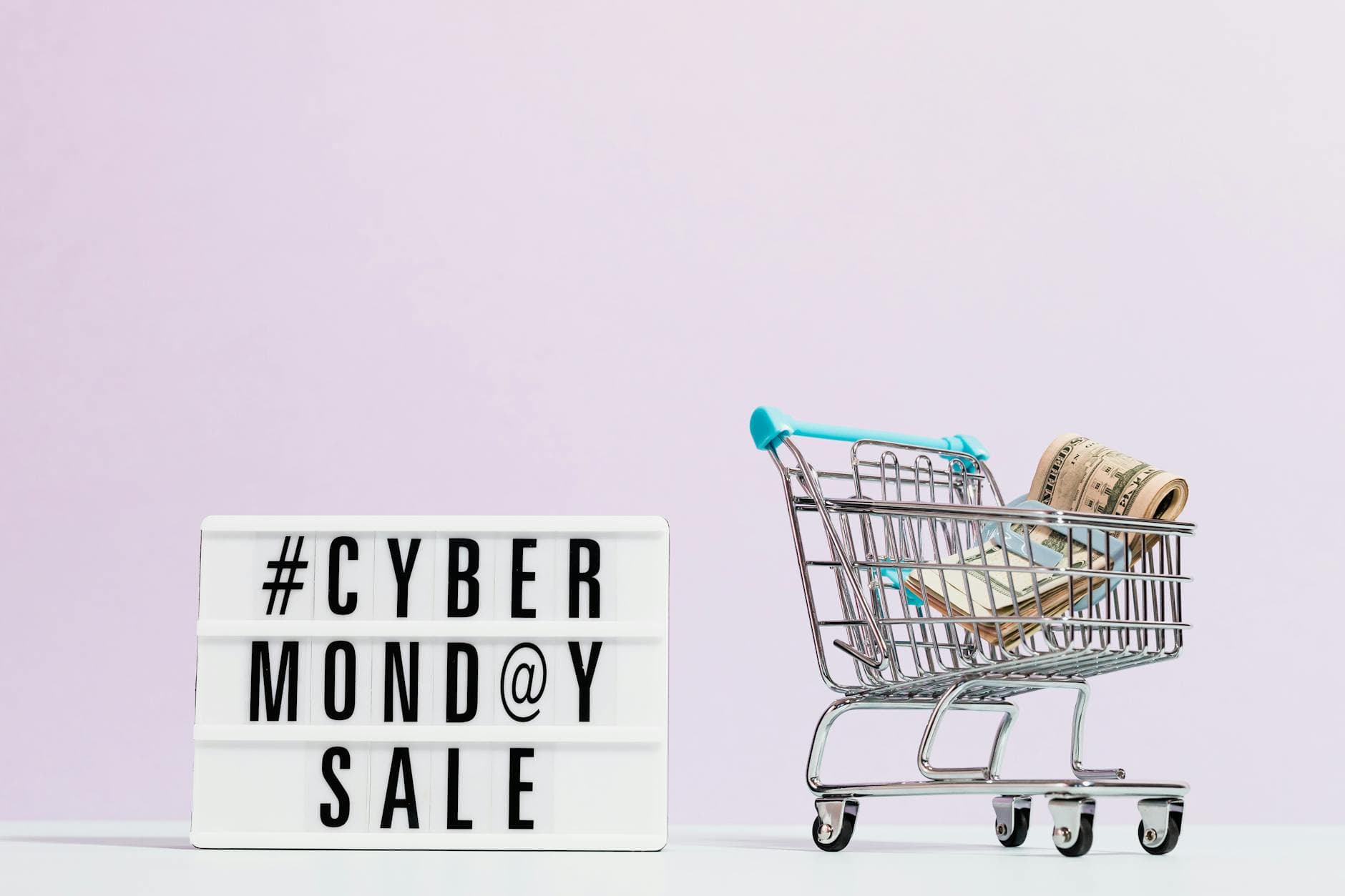 Shopping cart filled with cash beside a Cyber Monday sale sign, perfect for retail promotions.