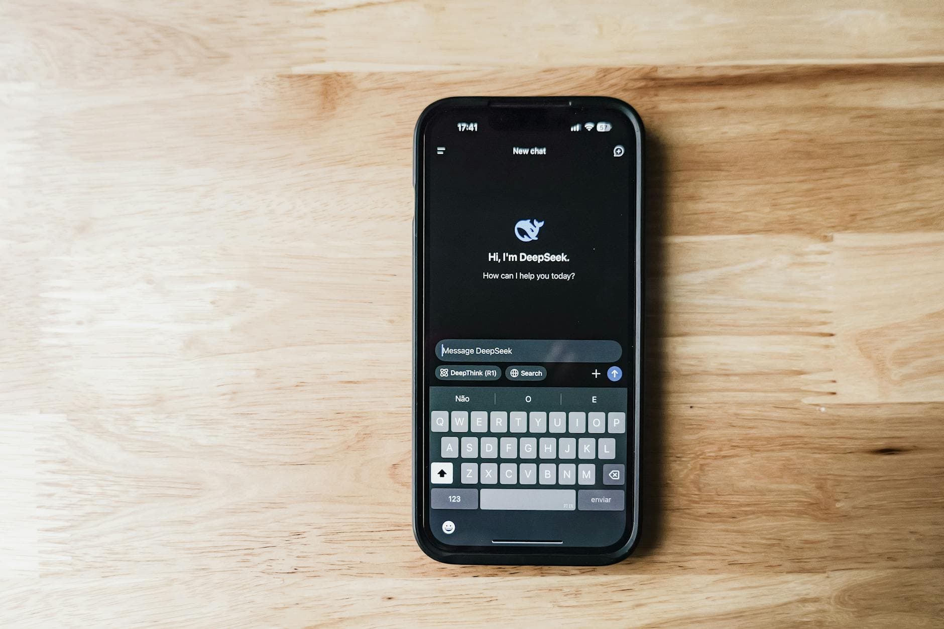 A smartphone on a wooden table showing an AI chatbot interface called DeepSeek.